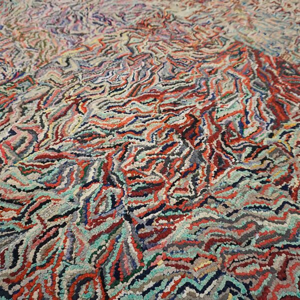 Close-up of a vibrant, multicolored rag rug with wavy, textured patterns by rugs on net. By rugs on net