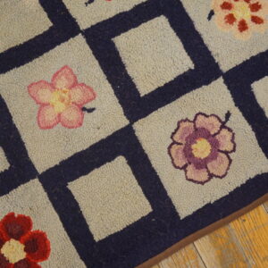 Close-up of a hooked rug featuring a checkerboard pattern with colorful flowers, by Rugs On Net. by Rugs On Net