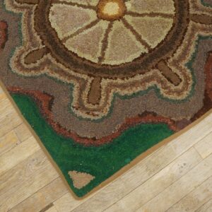 Close-up of a hooked rug with a circular, earthy design on light wood flooring by Rugs On Net