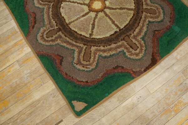 Close-up of a hooked rug with a circular, earthy design on light wood flooring by rugs on net