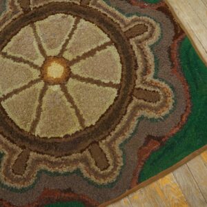 Close-up of a hooked rug featuring a circular, wheel-like design in earthy tones of brown and tan, set against a green border, by Rugs On Net. by Rugs On Net