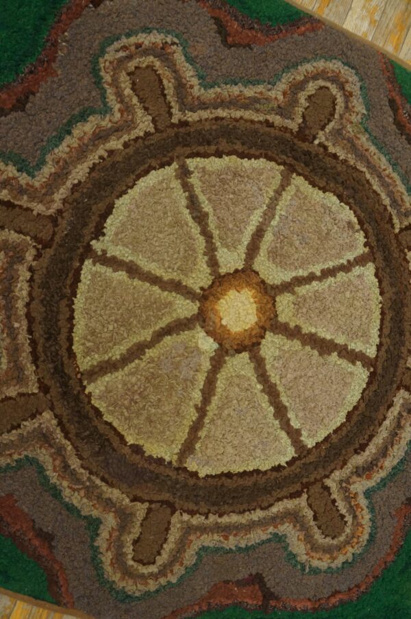 Close-up of a circular, earthy-toned rug pattern resembling a stylized sun or wheel, by rugs on net. By rugs on net