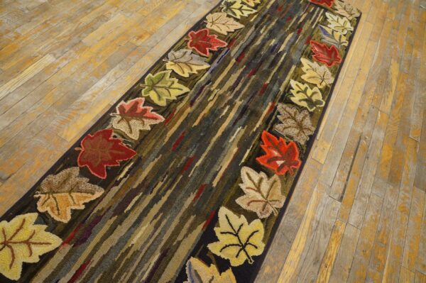 A hook rug runner with colorful autumn leaves bordering a center of abstract vertical stripes, by rugs on net. By rugs on net