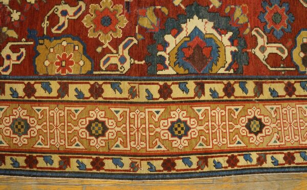 Close-up of a richly colored rug border featuring geometric and stylized floral motifs in red, gold, and blue by rugs on net. By rugs on net