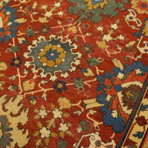 Close-up of a richly colored red rug with blue and cream medallions, by Rugs On Net