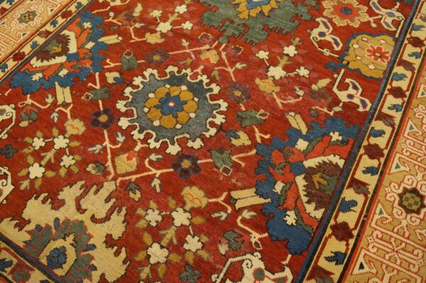 Close-up of a richly colored red rug with blue and cream medallions, by rugs on net