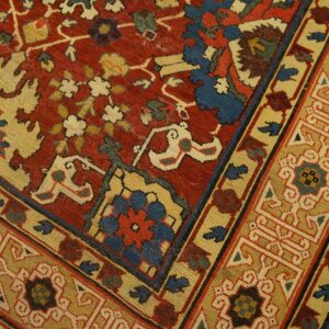 Close-up of a richly colored rug featuring red, cream, and blue geometric patterns, by Rugs On Net. by Rugs On Net