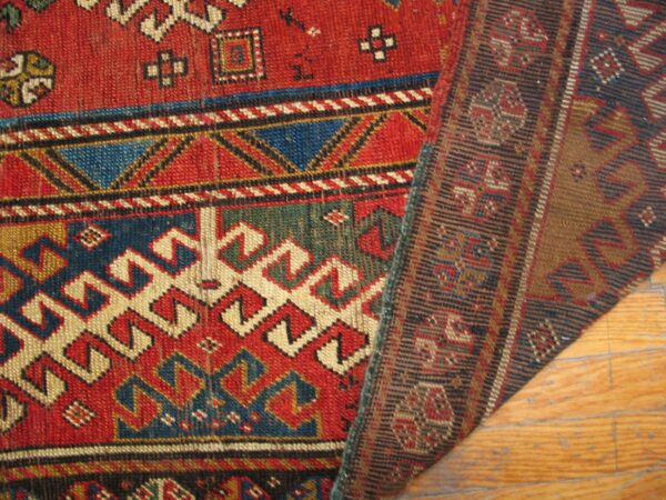Close-up of a richly colored, geometric rug design, showing the texture and border, by rugs on net