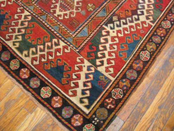 Corner detail of a richly colored geometric rug, possibly caucasian, by rugs on net