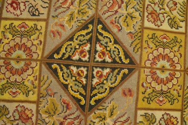 Close-up of a tapestry rug with geometric and floral patterns in yellow, red, and black by rugs on net