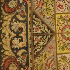 Close-up of a needlepoint rug with floral squares and a dark border, by Rugs On Net