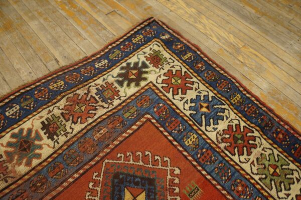 Close-up corner detail of a richly colored antique rug on a distressed wooden floor by rugs on net