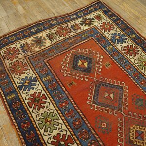 Close-up of a richly colored antique rug with geometric patterns on a distressed wooden floor by Rugs On Net. by Rugs On Net