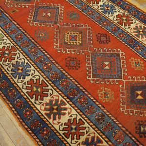 Close-up of a vibrant red runner rug with geometric medallions and blue borders, by Rugs On Net