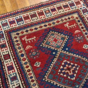 Close-up of a red and blue geometric rug pattern by Rugs On Net