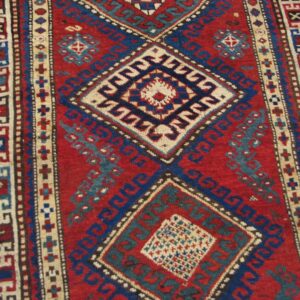 Close-up of a vibrant red and blue geometric rug pattern, featuring diamond medallions, by Rugs On Net. by Rugs On Net