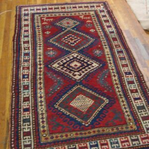 A close-up view of a vibrant red and blue geometric runner rug, likely a Caucasian design, by Rugs On Net. by Rugs On Net