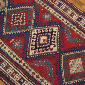Close-up of a red and blue geometric rug pattern by Rugs On Net. by Rugs On Net