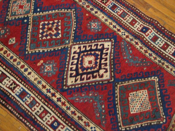 Close-up of a red and blue geometric rug pattern by rugs on net. By rugs on net