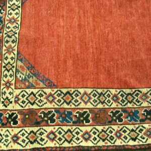 Close-up of a red field rug border with geometric patterns by Rugs On Net