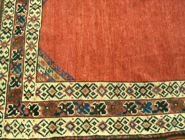 Close-up of a red field rug border with geometric patterns by rugs on net
