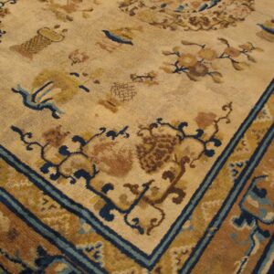 Close-up of a beige and brown antique rug with blue accents, featuring floral and symbolic motifs, by Rugs On Net
