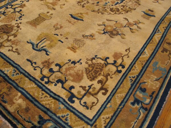 Close-up of a beige and brown antique rug with blue accents, featuring floral and symbolic motifs, by rugs on net