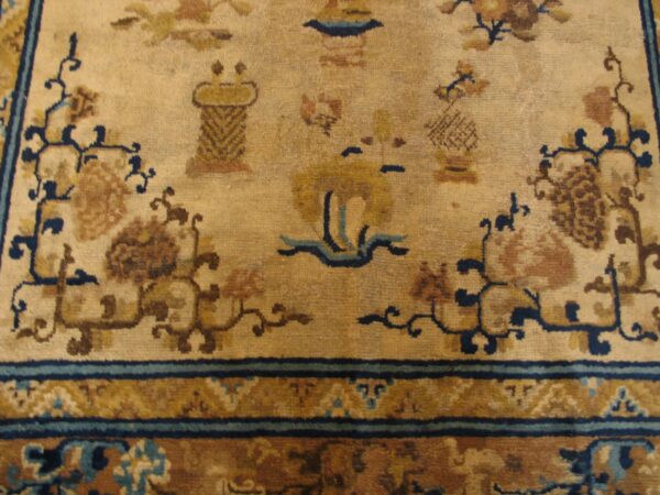 Close-up of a beige field with brown and blue motifs from the antique chinese rug by rugs on net. By rugs on net