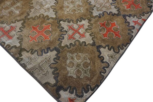 Close-up of a brown rug with repeating orange and beige geometric motifs by rugs on net
