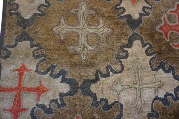 Close-up of a brown and beige rug with repeating stylized cross motifs by rugs on net