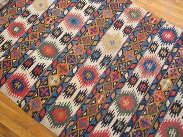 Close-up view of a colorful kilim rug with diagonal stripes and geometric motifs, by rugs on net
