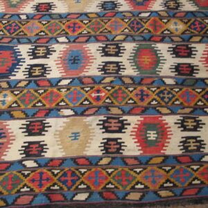 Close-up of a colorful kilim rug with geometric patterns on a light field by Rugs On Net
