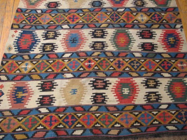 Close-up of a colorful kilim rug with geometric patterns on a light field by rugs on net