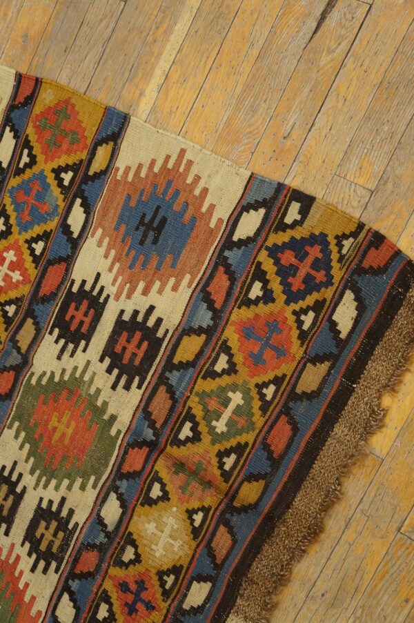 Close-up of a colorful kilim rug with geometric patterns on a wooden floor by rugs on net