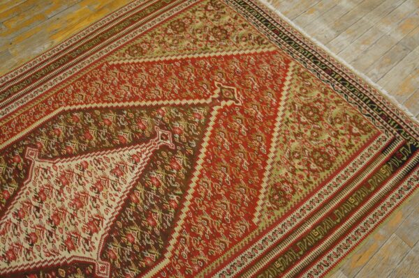 Close-up of a vibrant red and green kilim rug with geometric patterns on a light wood floor by rugs on net