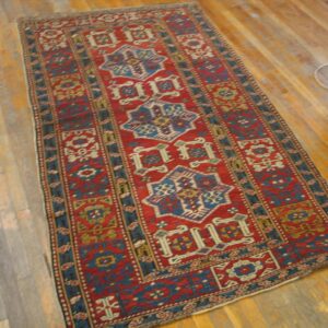 A vibrant red and blue runner rug with geometric patterns on a wooden floor by Rugs On Net. by Rugs On Net