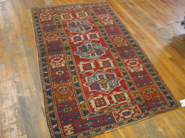 A vibrant red and blue runner rug with geometric patterns on a wooden floor by rugs on net. By rugs on net
