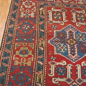 Close-up of a red and blue geometric pattern on the Kazak rug by Rugs On Net. by Rugs On Net