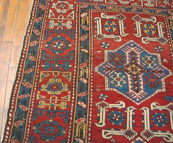 Close-up of a red and blue geometric pattern on the kazak rug by rugs on net. By rugs on net