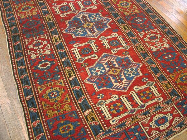 Close-up of a vibrant red and blue geometric runner rug by rugs on net. By rugs on net
