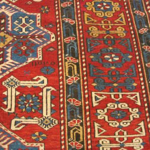 Close-up of a red and blue geometric Caucasian rug by Rugs On Net. by Rugs On Net