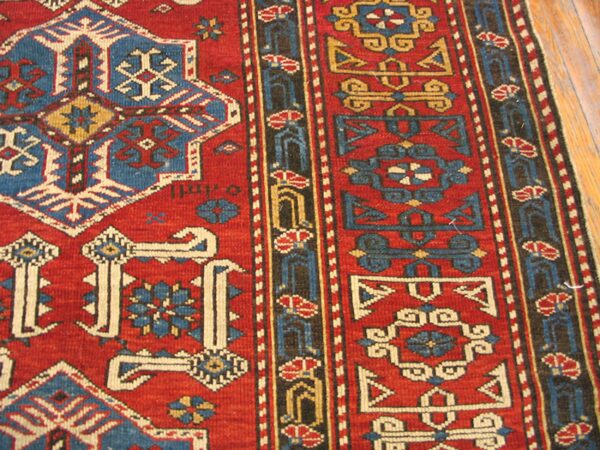 Close-up of a red and blue geometric caucasian rug by rugs on net. By rugs on net