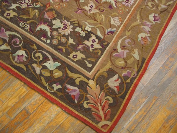 Close-up corner view of a dark brown floral tapestry rug on a wooden floor by rugs on net. By rugs on net