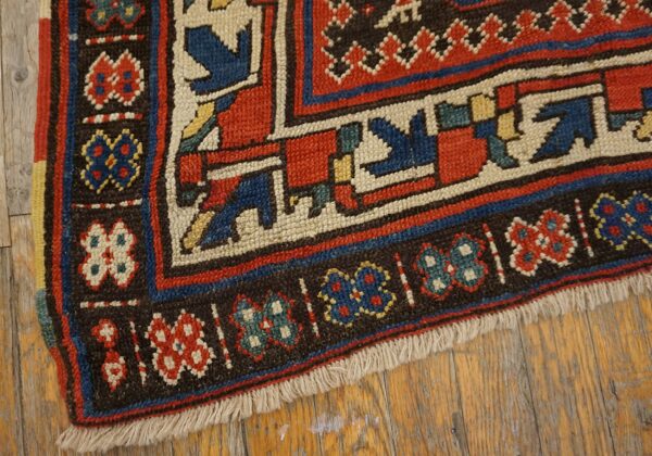 Close-up of the border of a colorful antique rug with geometric motifs by rugs on net. By rugs on net