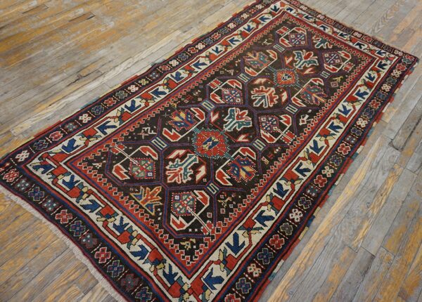 A dark, geometric caucasian rug featuring red, blue, and cream accents on a distressed wooden floor by rugs on net. By rugs on net