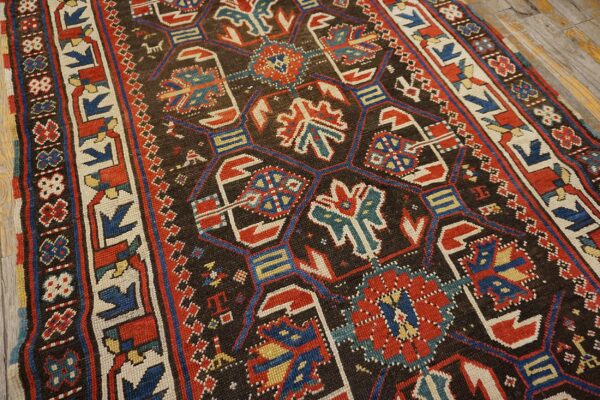 Close-up of a dark ground caucasian rug with geometric motifs in red, blue, and cream by rugs on net