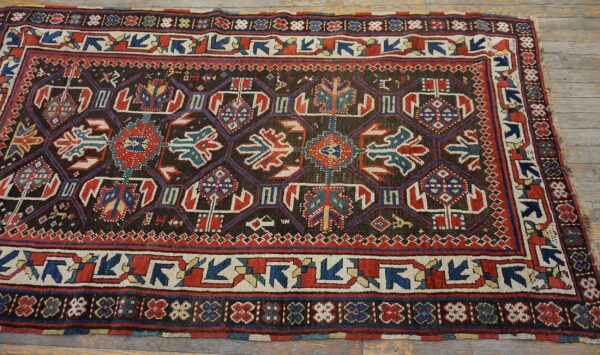 Close-up of a dark field tribal rug with geometric medallions in red, blue, and cream by rugs on net