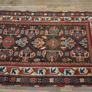 A close-up view of a richly patterned antique rug featuring geometric motifs in dark brown, red, and blue, by Rugs On Net. by Rugs On Net