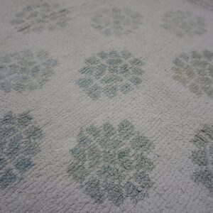 Faded floral pattern on cotton carpet