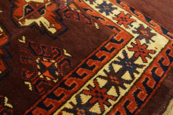 Close-up of the intricate border design on a deep red and brown rug by rugs on net. By rugs on net
